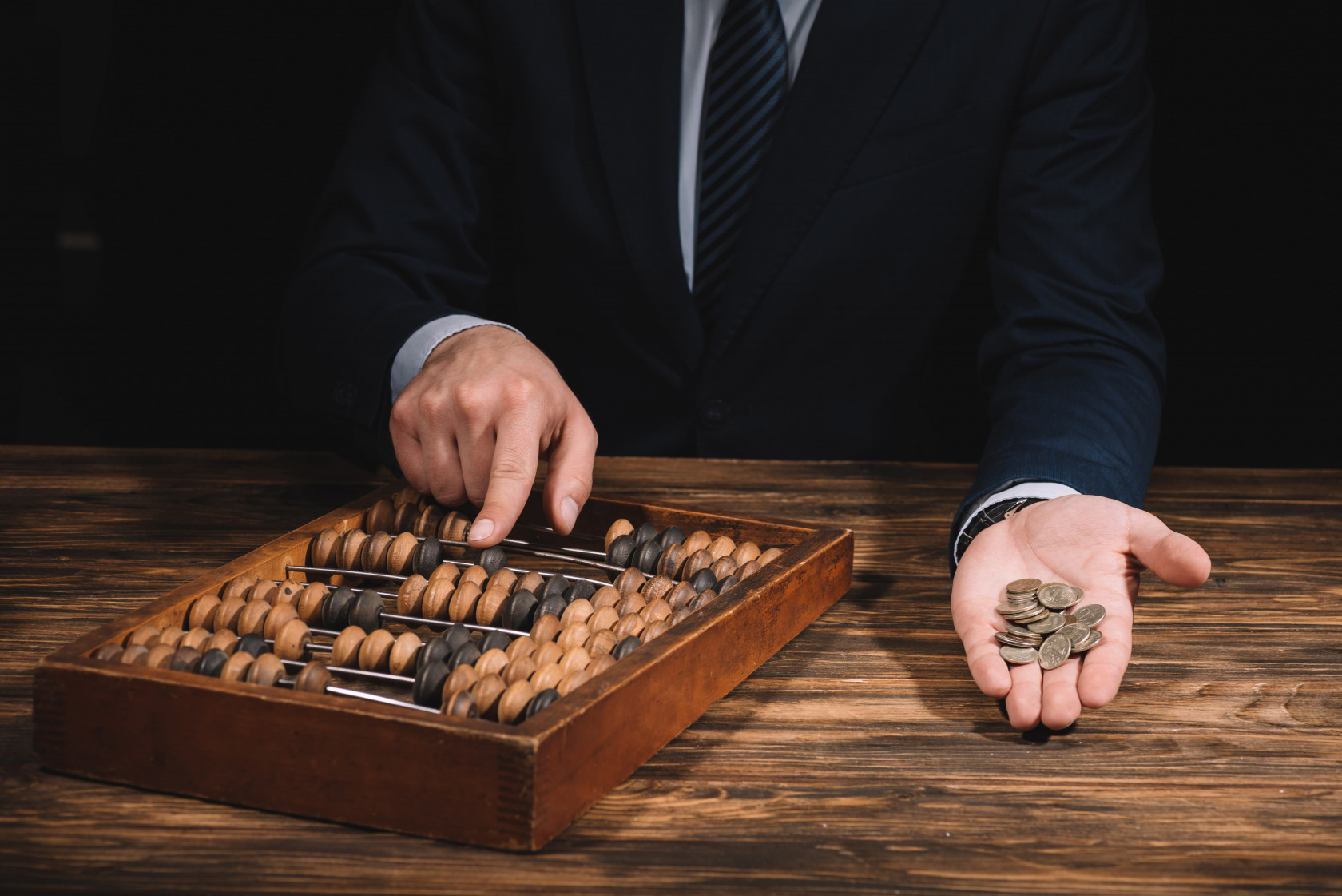 cropped-shot-of-businessman-holding-coins-and-usin-2021-08-30-02-15-40-utc-min.jpg